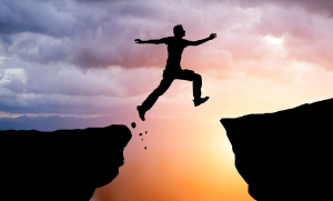 man jumping between peaks